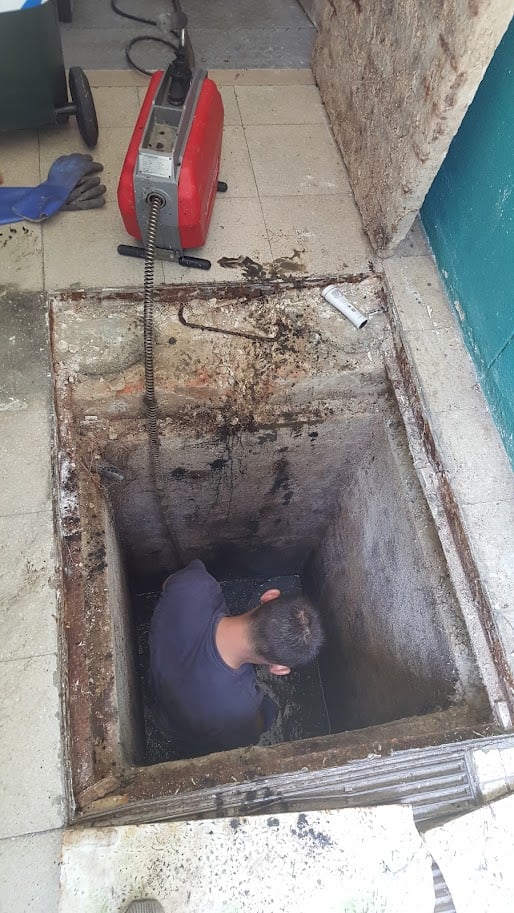canalizador na linha a desentupir uma caixa de esgoto de gordura